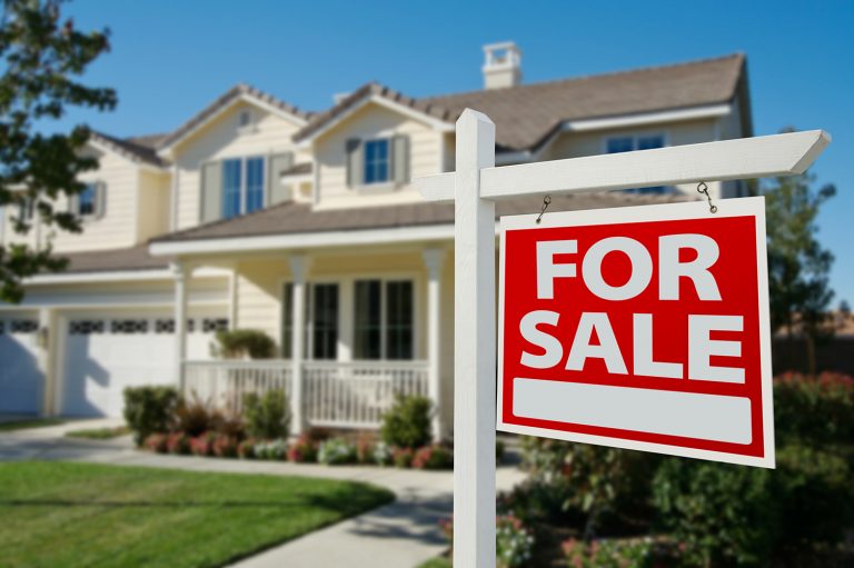 House with for sale sign in yard