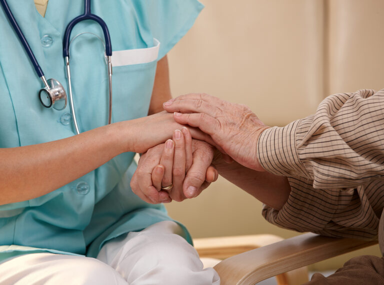 Nurse holding patient's hands after COVID-19 vaccination