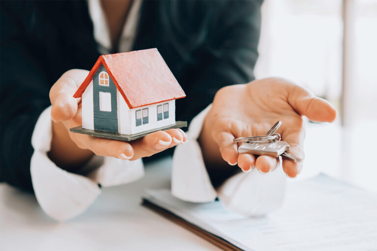 Real estate agent handing over keys to new house after it is sold.