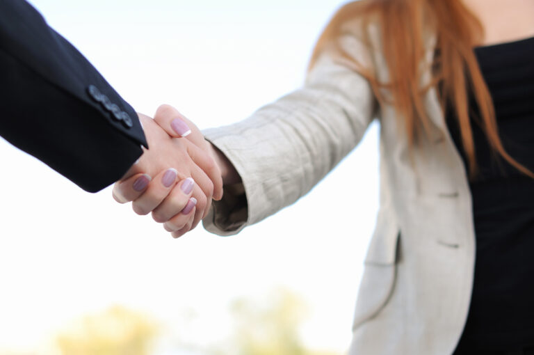 Real estate professional shaking hands with client.