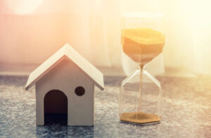 Hourglass and house - time to sell home concept
