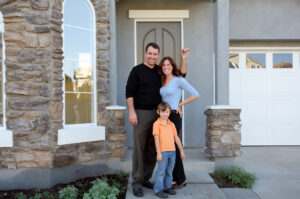 Happy family in front of new home, moving to a new city concept!