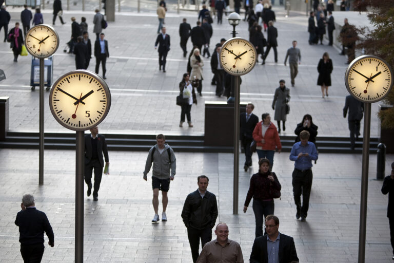 Commuters in train station, representing hybrid work environment and housing challenges.