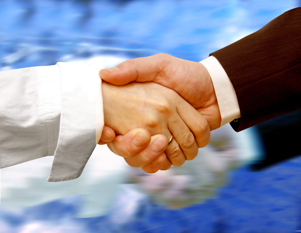 Man and woman shaking hands, representing negotiation in real estate sales.