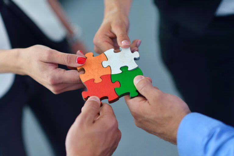 People holding puzzle pieces, concept for buying and selling real estate as a partial owner/joint ownership