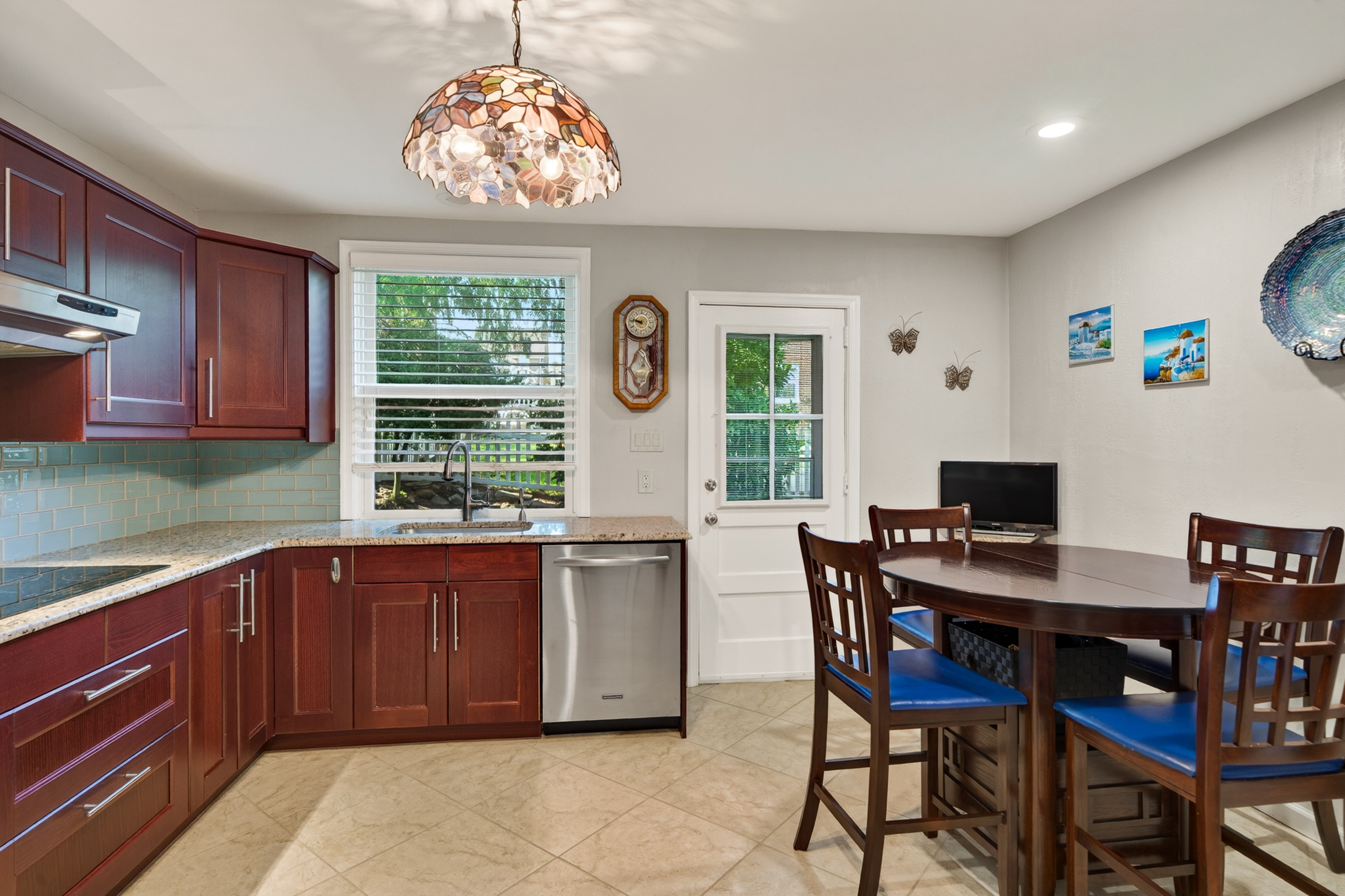 Renovated kitchen with induction cooktop, granite counters, and cherry cabinetry