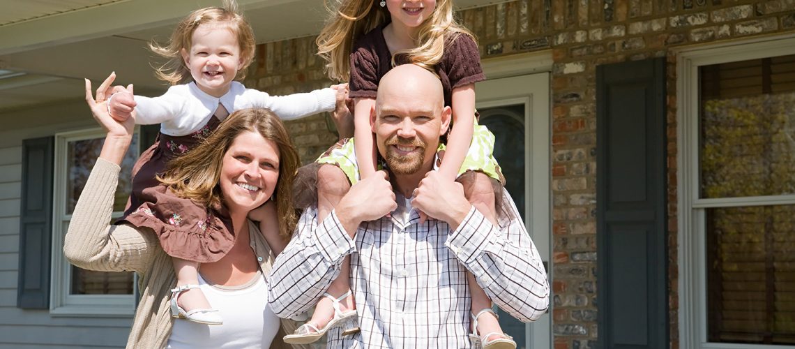 Family in front of house, representing planning a move with family.