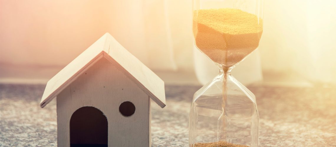 Hourglass and house - time to sell home concept